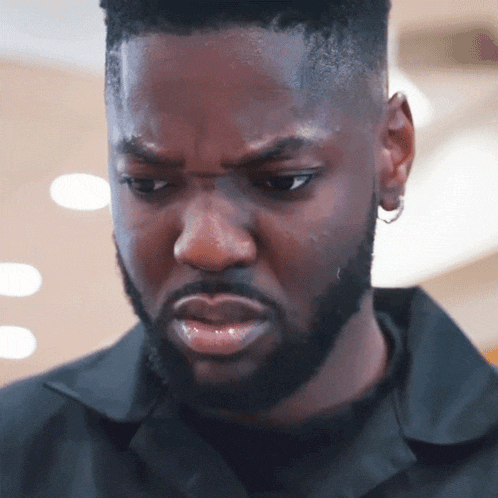 a man with a beard is wearing a black shirt and earring