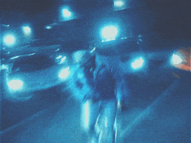 a blurry photo of a man walking in a parking lot taken by the maw