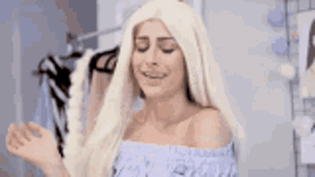 a woman with blonde hair is wearing a blue off the shoulder top and says da licença querida