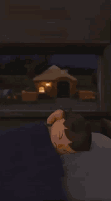 a cartoon character is sleeping in a bed in front of a window with a house in the background .