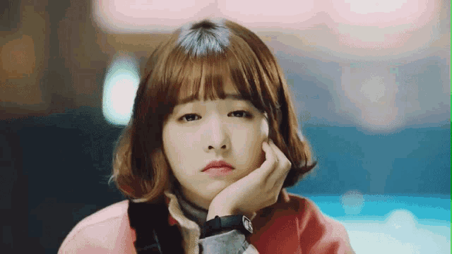 a young woman with a watch on her wrist looks sad