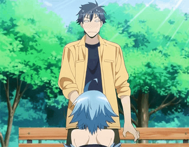 a man and a woman are standing next to each other on a bench in a park .