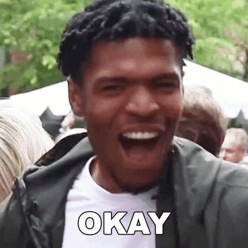 a man is laughing with the word okay written on his face .