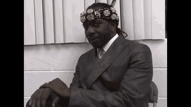 a man in a suit has a headband on his head
