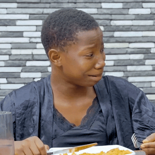 a woman eating a plate of food with a fork and knife