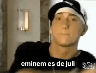 a close up of a man wearing a baseball cap and a black shirt .