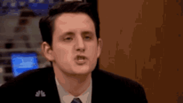a man wearing a suit and tie is making a funny face .