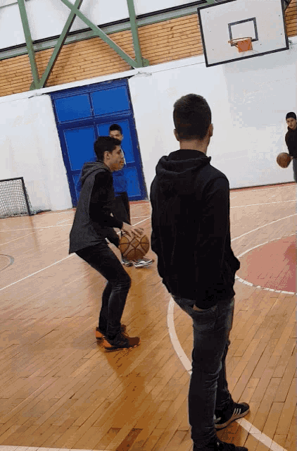 a group of boys are playing basketball on a court