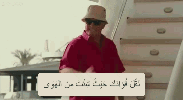 a man wearing a bucket hat and sunglasses is standing on a set of stairs ..