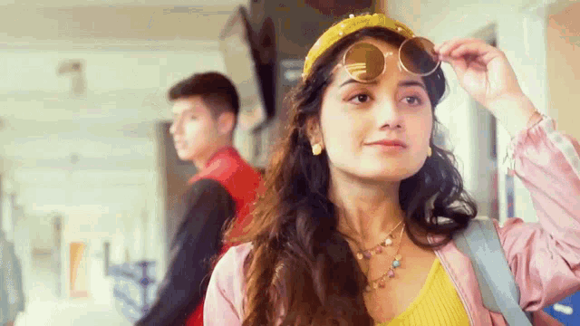 a woman wearing sunglasses and a yellow headband