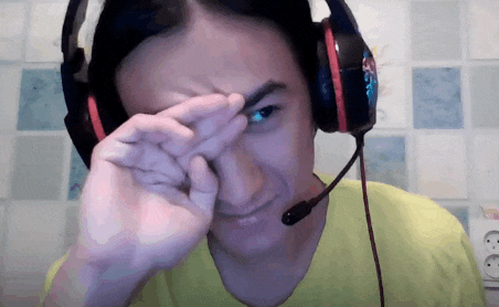a man wearing headphones and a microphone wipes his eyes with his hand