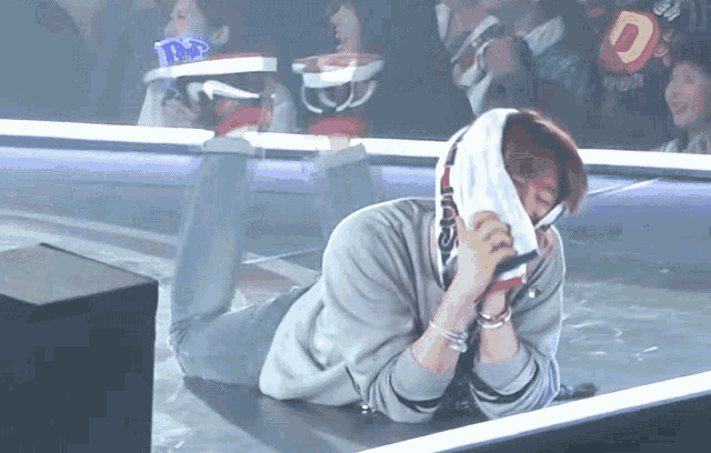 a man is laying on the floor with a towel over his face and a sign that says d.p. on it