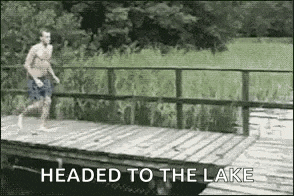 a man is jumping off a wooden bridge into the water .
