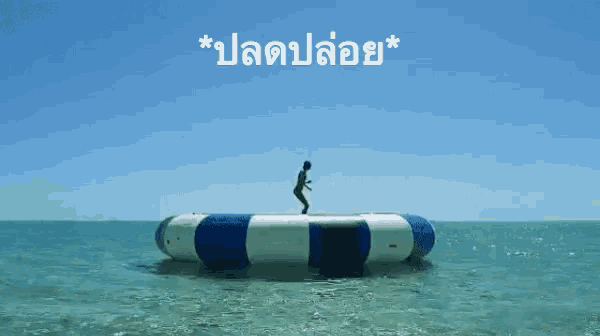 a blue and white raft in the ocean with the words * ปลดปล่อย * written above it