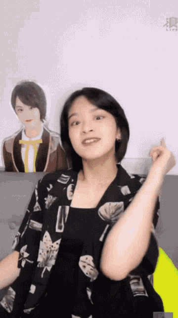 a woman is sitting on a couch in front of a poster of a boy