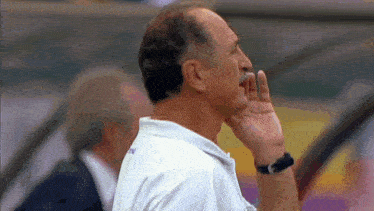 a man with a mustache is wearing a watch and whispering