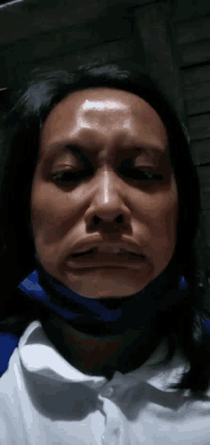 a woman wearing a blue face mask is making a funny face .