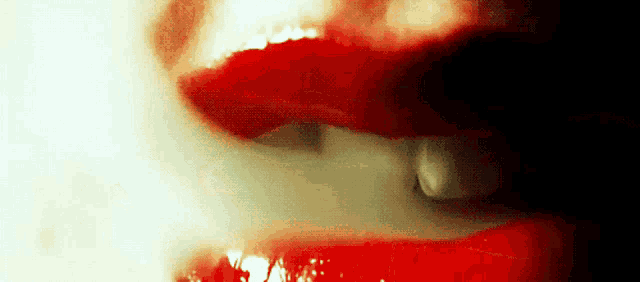a close up of a woman 's mouth with red lips and white teeth