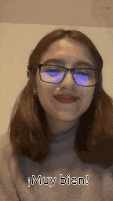 a woman wearing glasses and a sweater says muy bien in spanish