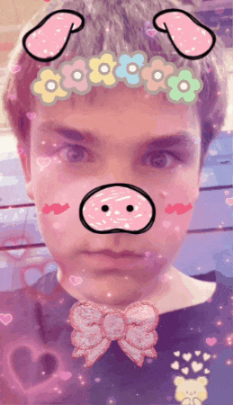 a boy with a pig face and flowers on his head