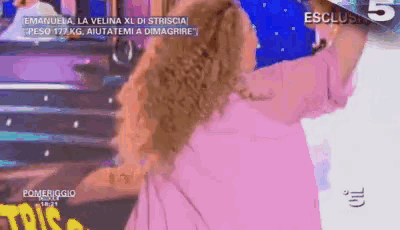 a woman in a pink dress is dancing on a television show
