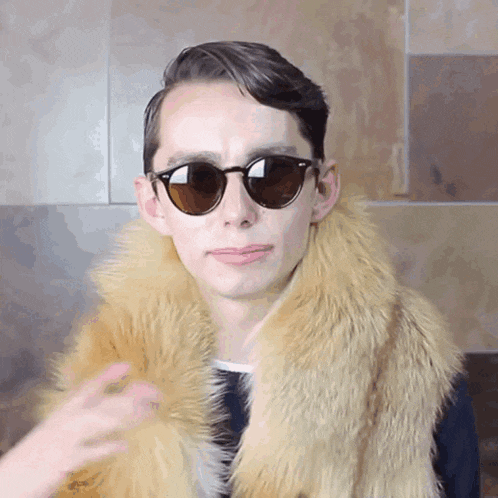 a man wearing sunglasses and a fur scarf around his neck