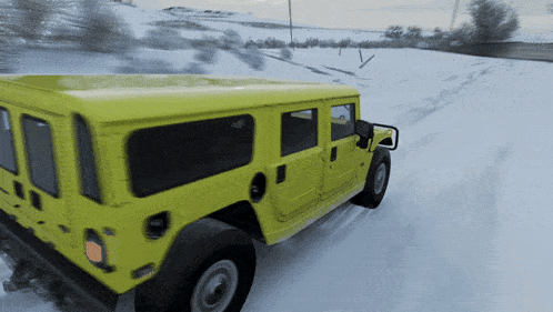 a yellow vehicle is driving through the snow on a snowy road