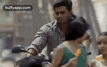 a man is riding a motorcycle with a child on the back of it .