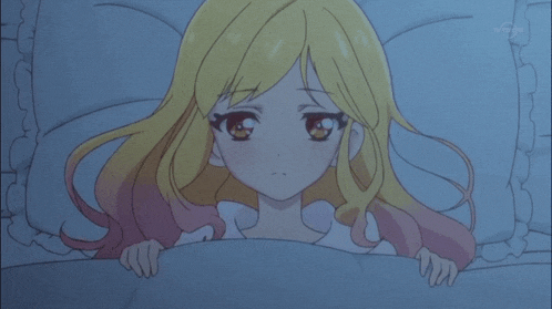 a girl with blonde hair and red eyes is hiding under a blanket in a bed