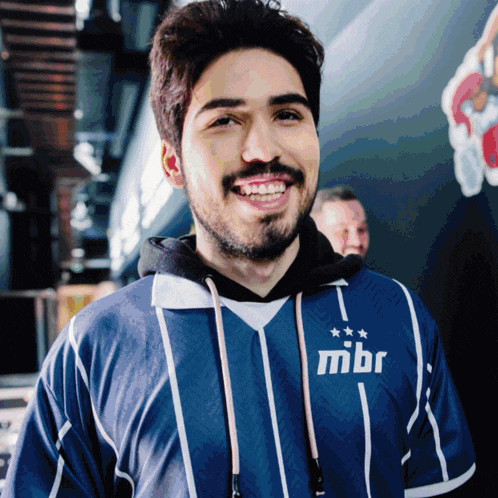 a man wearing a blue and white striped shirt with the word mbr on the front