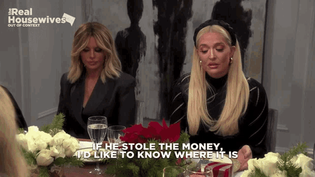 two women are sitting at a table with a sign that says real housewives out of context