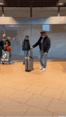 a man with a suitcase is being pushed by another man in a tiktok video