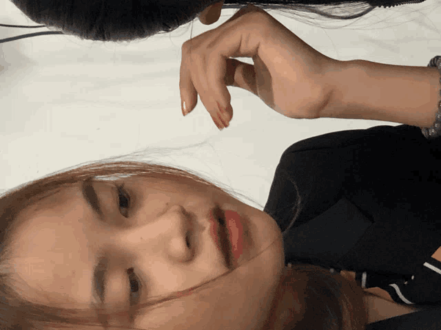 a close up of a woman 's face with her hand on her head