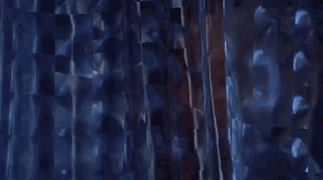 a person is holding a knife in their hand in front of a wall .