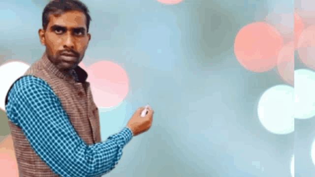 a man in a plaid shirt and vest is holding a pen