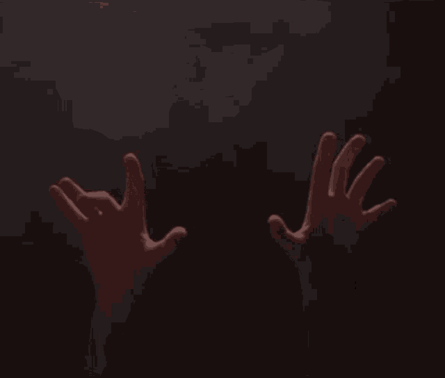 a pair of hands reaching up in the dark