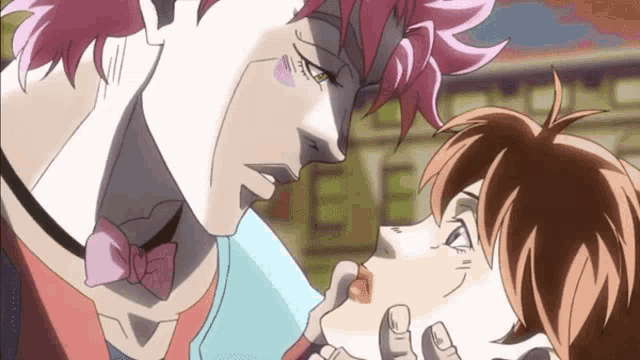 a man with pink hair is kissing another man with brown hair