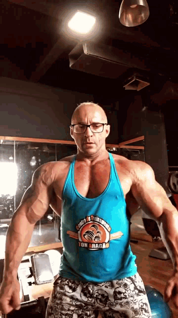 a man in a gym wearing a tank top that says ton aragas on it