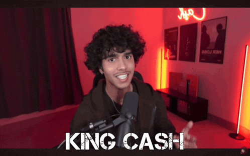a man with curly hair is talking into a microphone with the words king cash written on the bottom