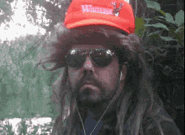 a man wearing a wig and sunglasses is wearing an orange hat that says walmart on it