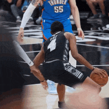 a basketball player with the number 55 on his jersey dribbles the ball