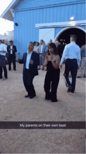 a man and a woman are dancing in front of a blue building with a caption that says my parents on their own beat