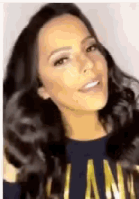 a close up of a woman 's face wearing a blue sweater with the word lan on it .