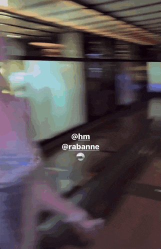a blurry picture of a person walking with the words @hm @rabanne visible