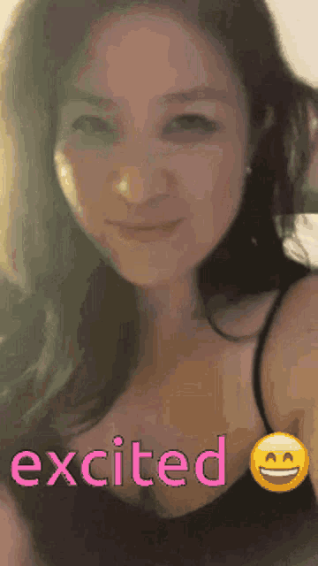 a woman in a black tank top with the word excited on the bottom