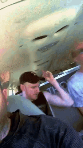 a man wearing a hat is sitting on a bus with a sign that says t on it