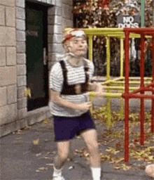a man is running in front of a no dogs sign .