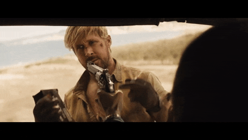 a man is holding a gun in front of another man in a car
