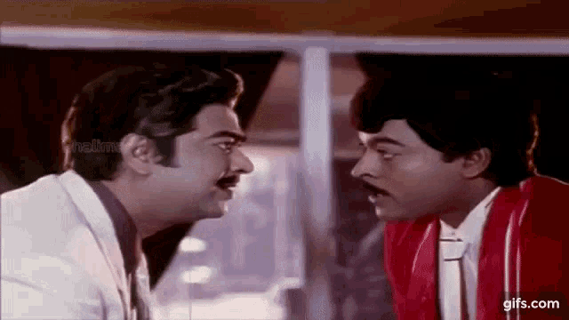 two men are looking at each other and making funny faces in a movie .
