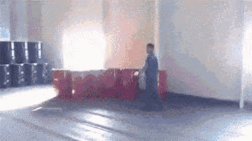 a man is standing in a room with barrels and a window .